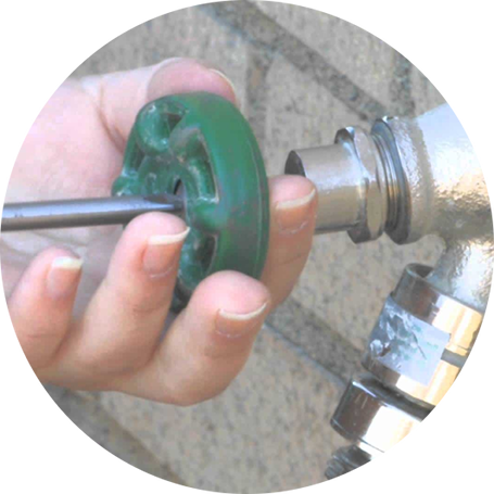 Plumber fixing an outdoor water tap