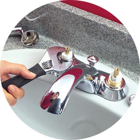 Plumber using a small wrench on a bathroom faucet